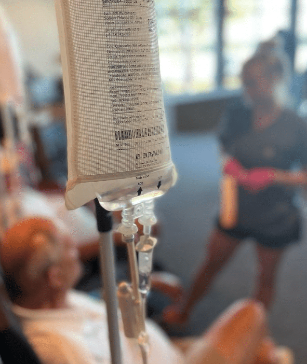 Female nurse administering mobile IV therapy at an event.